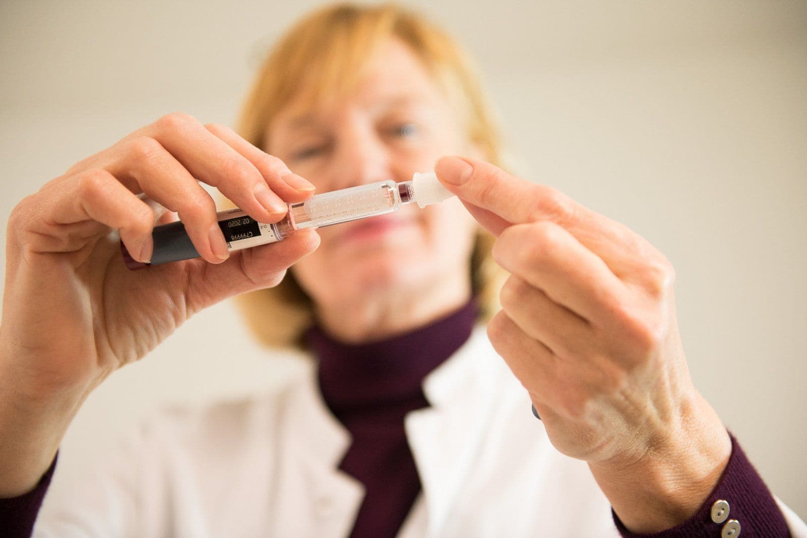 Eine Mitarbeiterin im weißen Kittel bereitet einen Insulin-Pen vor