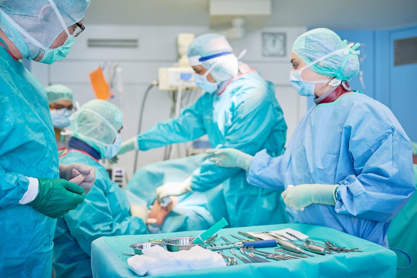 Operationsteam der Orthopädie bei einem Eingriff, im Vordergrund der Instrumententisch